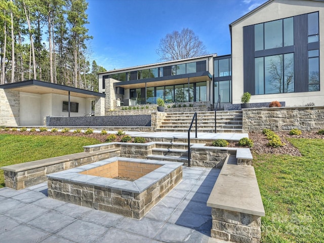 back of house featuring a fire pit, a patio, and stucco siding