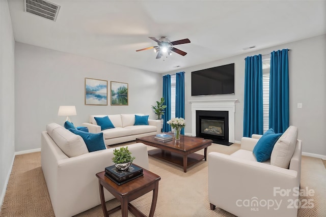 living room featuring a fireplace with flush hearth, visible vents, ceiling fan, and baseboards