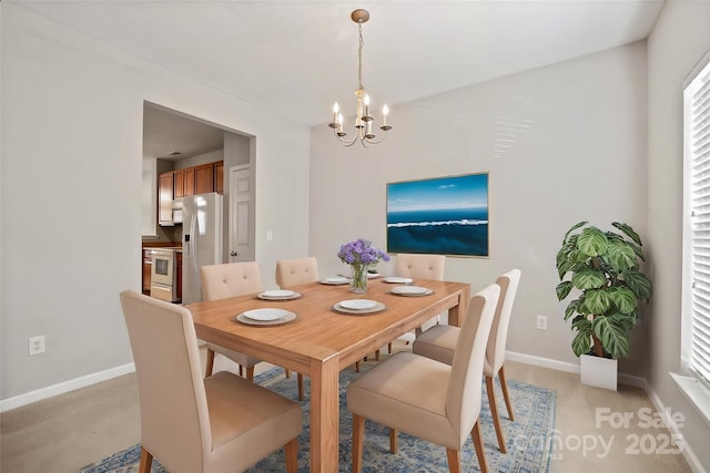 dining area featuring a chandelier and baseboards