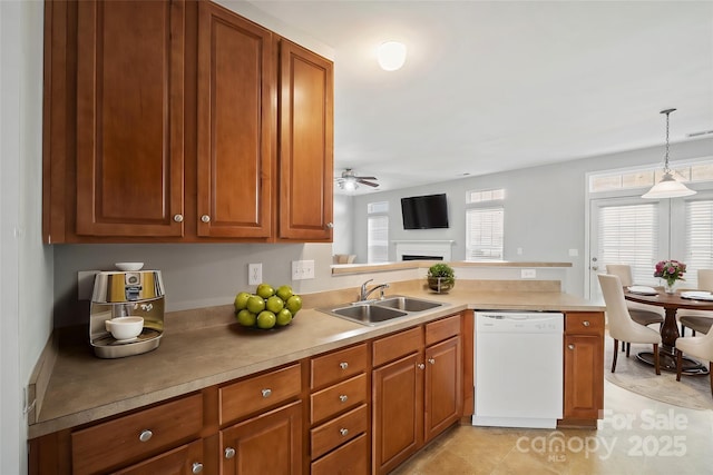 kitchen with a sink, a peninsula, brown cabinetry, and dishwasher