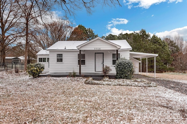 view of front of property with an attached carport, covered porch, and fence