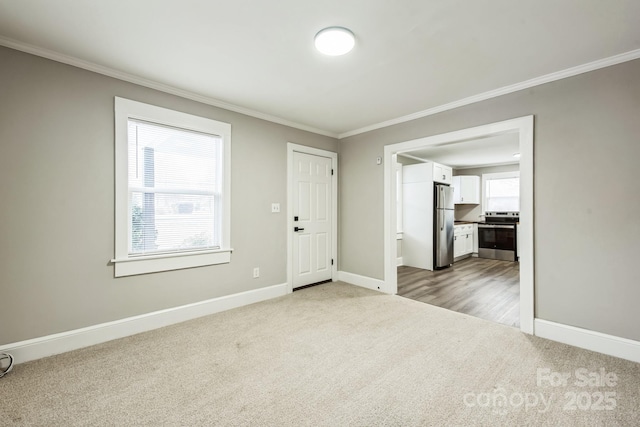 carpeted empty room with ornamental molding and baseboards