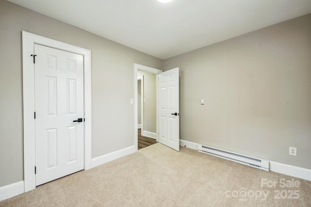 unfurnished bedroom featuring carpet floors, a baseboard radiator, and baseboards