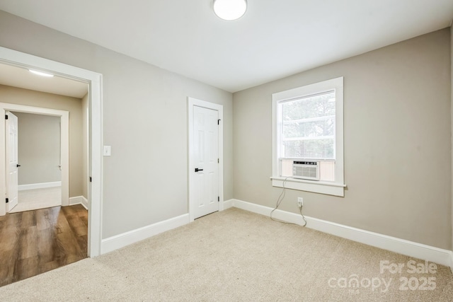 empty room featuring carpet floors, cooling unit, and baseboards