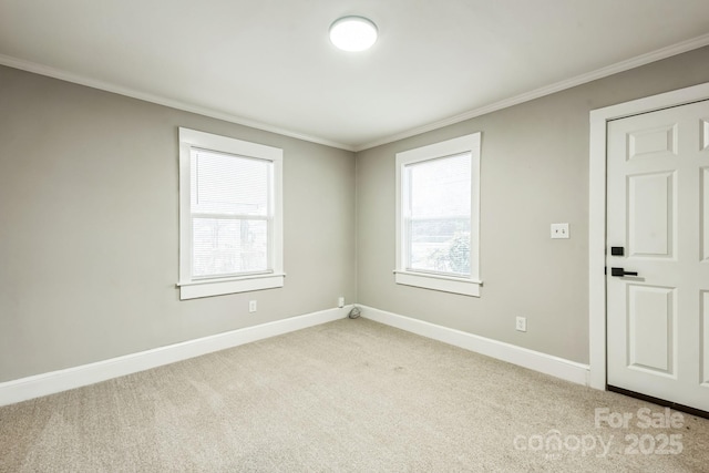 empty room featuring light carpet, a healthy amount of sunlight, crown molding, and baseboards