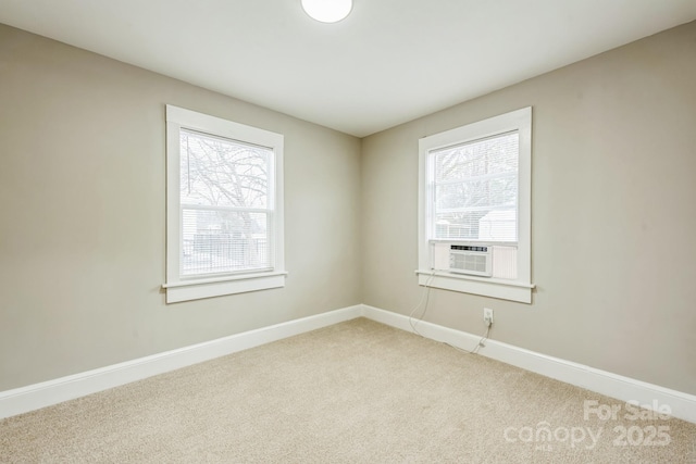 carpeted empty room featuring a healthy amount of sunlight, baseboards, and cooling unit