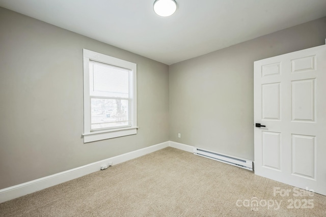 spare room with light carpet, a baseboard radiator, and baseboards