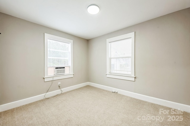 carpeted empty room featuring baseboards