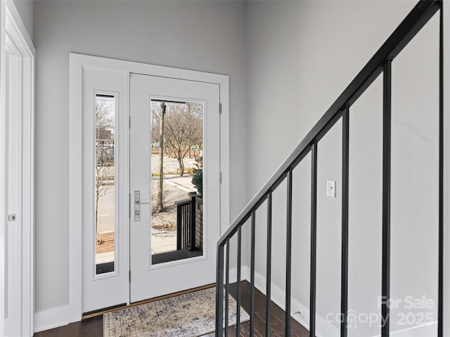 doorway to outside featuring stairs, baseboards, and dark wood-style flooring