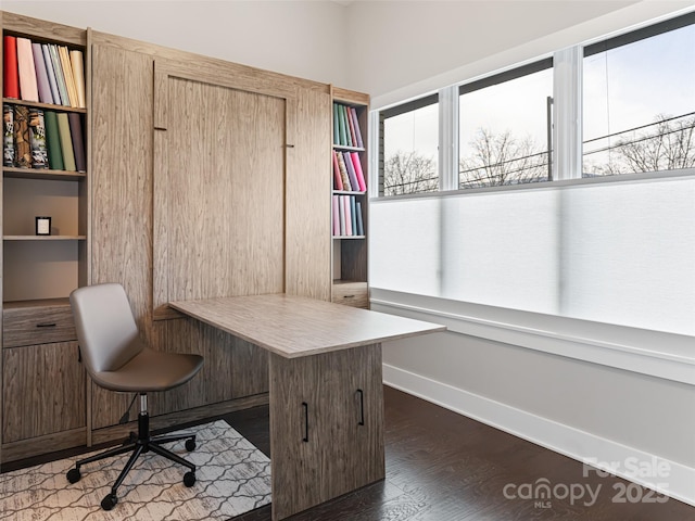 office featuring dark wood-style floors, built in desk, and baseboards