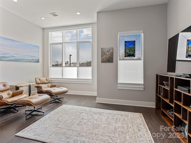 living area featuring visible vents, baseboards, dark wood finished floors, and recessed lighting