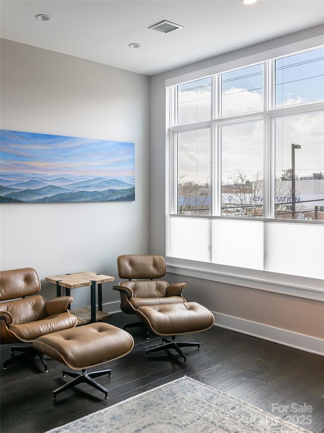 sitting room featuring dark wood-style flooring, visible vents, and baseboards