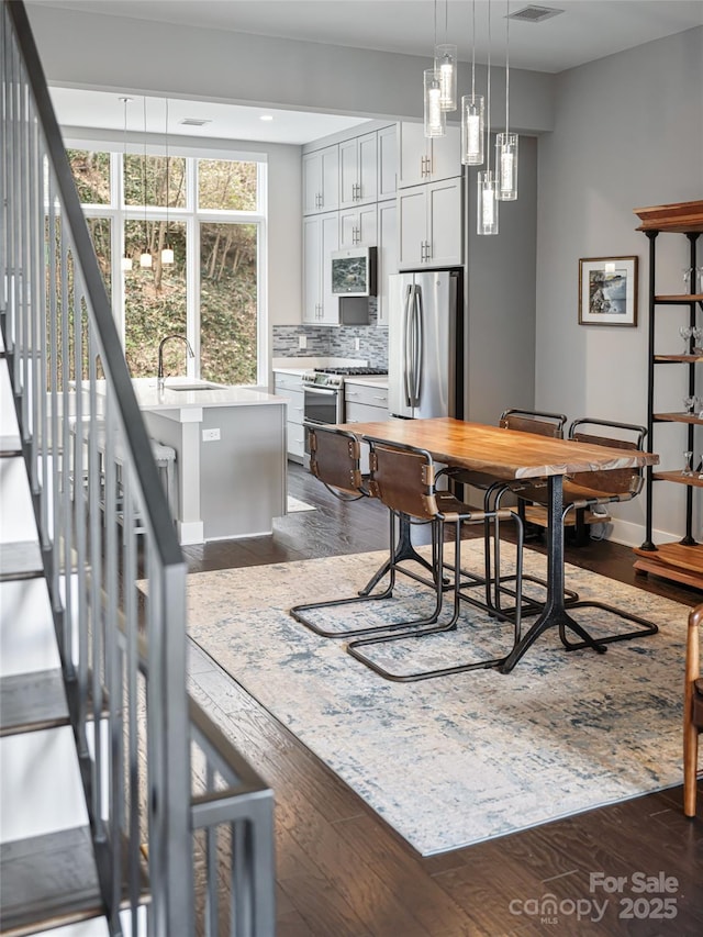 dining space with dark wood finished floors, stairway, and baseboards