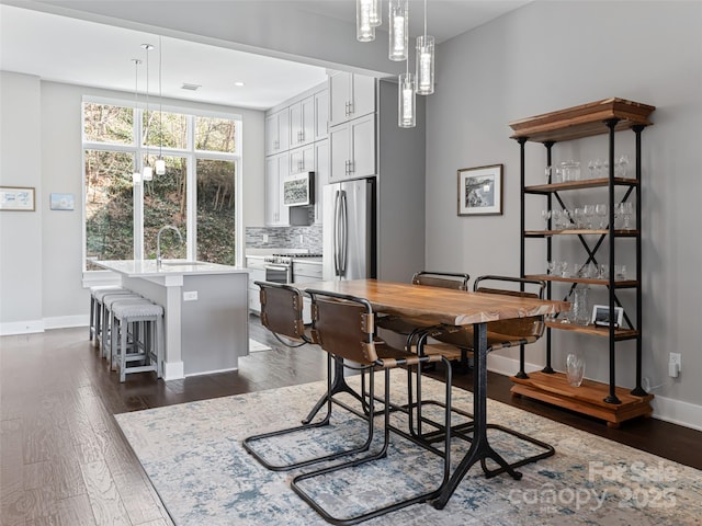 dining room with baseboards and dark wood-type flooring