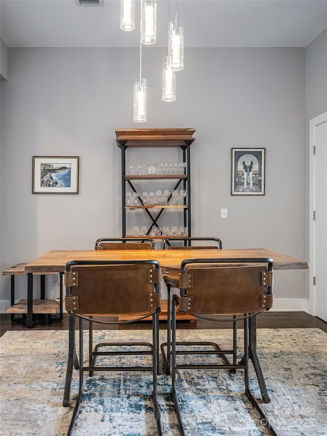 home office with wood finished floors, visible vents, and baseboards