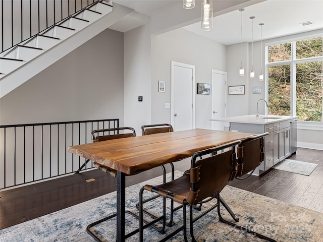 dining space with dark wood-type flooring, plenty of natural light, visible vents, and baseboards