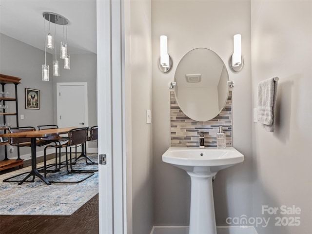 bathroom featuring tasteful backsplash, baseboards, and wood finished floors