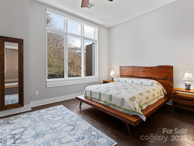 bedroom with dark wood-type flooring and baseboards