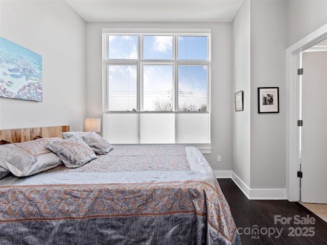 bedroom with dark wood finished floors and baseboards