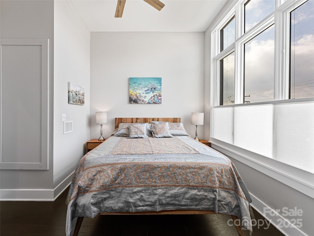 bedroom with dark wood-style floors, ceiling fan, and baseboards