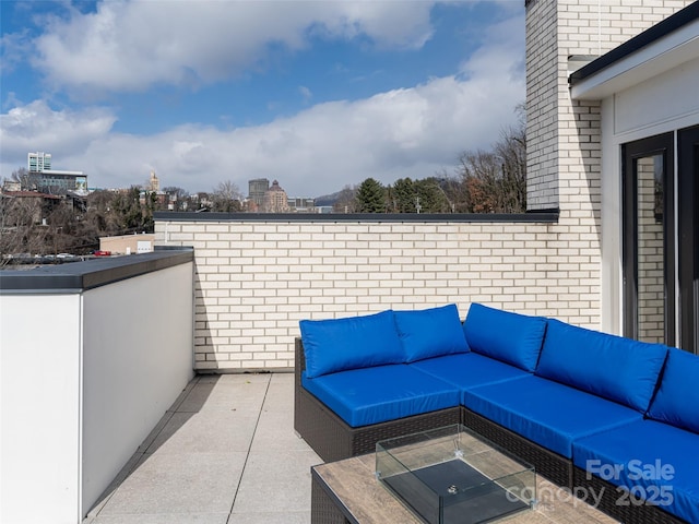 view of patio / terrace featuring an outdoor hangout area, a balcony, and a city view