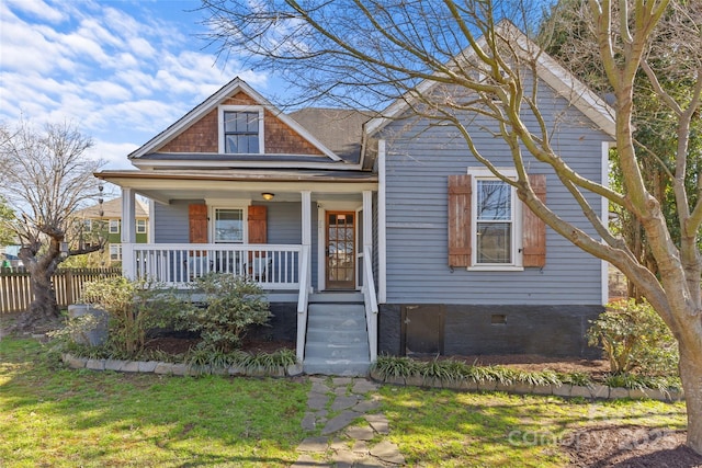 view of front facade with a porch, crawl space, and fence