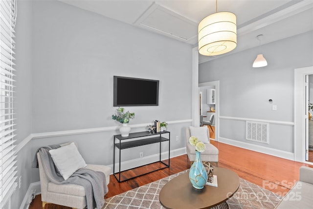 living room featuring wood finished floors, visible vents, and baseboards