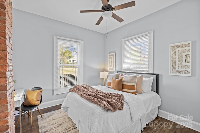 bedroom featuring ceiling fan, multiple windows, wood finished floors, and baseboards