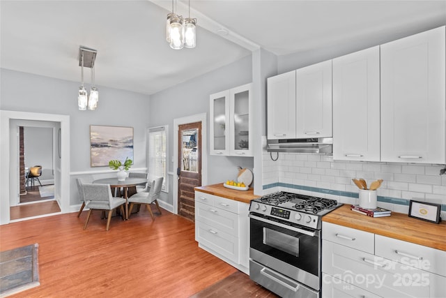 kitchen with stainless steel gas stove, light wood finished floors, white cabinets, wood counters, and under cabinet range hood