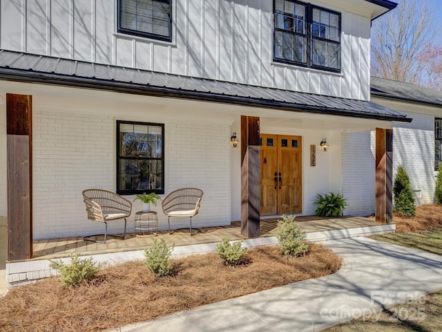 view of front of house featuring a porch, board and batten siding, and brick siding