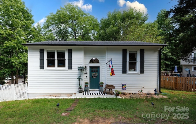 view of front of home with a front yard and fence