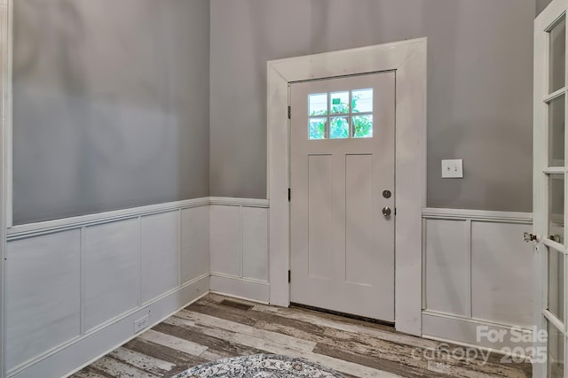 entrance foyer with wainscoting and wood finished floors