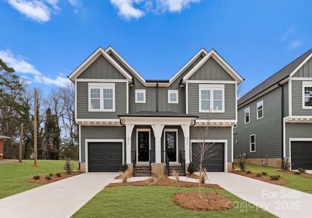 craftsman house featuring board and batten siding, a front yard, and a garage