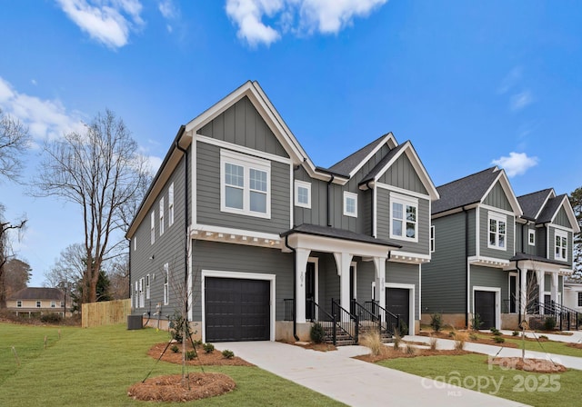 craftsman-style house with a garage, concrete driveway, board and batten siding, and a front yard