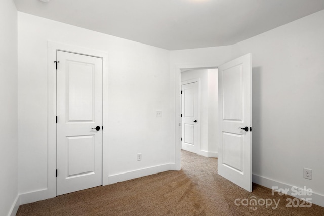 unfurnished bedroom featuring carpet floors and baseboards