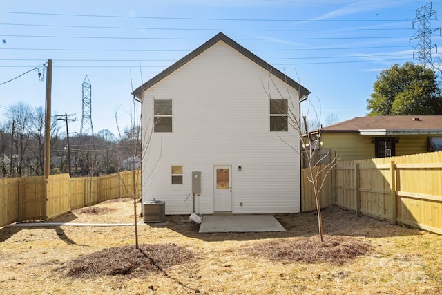 rear view of house featuring a patio area, a fenced backyard, and central air condition unit