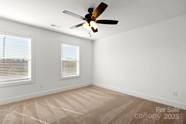 spare room featuring ceiling fan, carpet flooring, visible vents, and baseboards