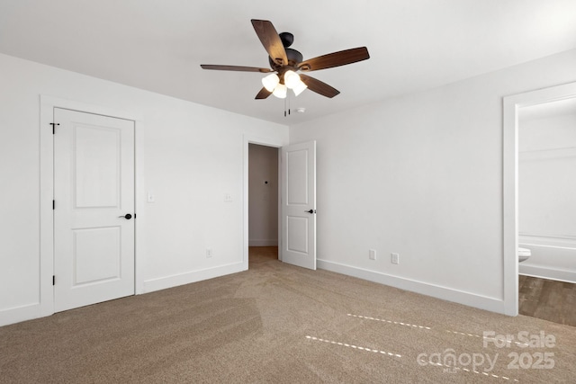 unfurnished bedroom featuring carpet floors, ceiling fan, baseboards, and ensuite bathroom