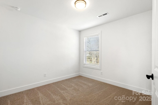 carpeted empty room featuring visible vents and baseboards