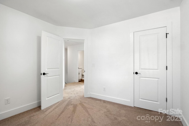 unfurnished bedroom featuring light colored carpet and baseboards