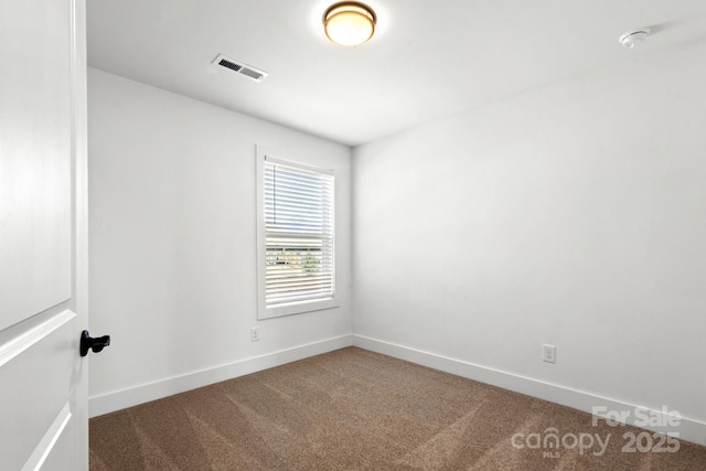 carpeted spare room featuring visible vents and baseboards