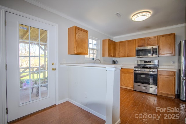 kitchen featuring visible vents, dark wood-style floors, appliances with stainless steel finishes, light countertops, and crown molding