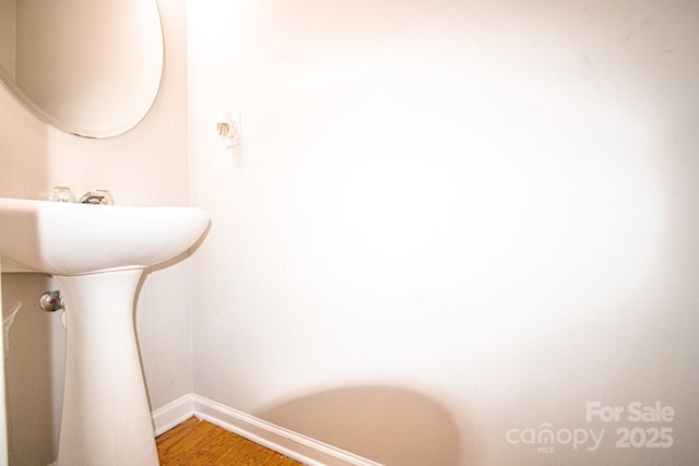 bathroom with baseboards and wood finished floors