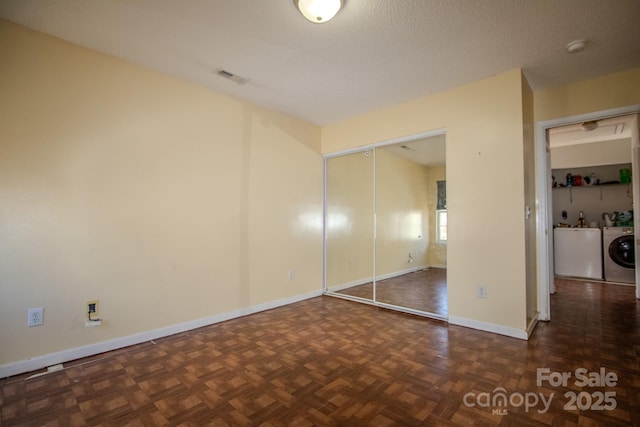 unfurnished bedroom featuring baseboards, visible vents, washer and clothes dryer, and a closet