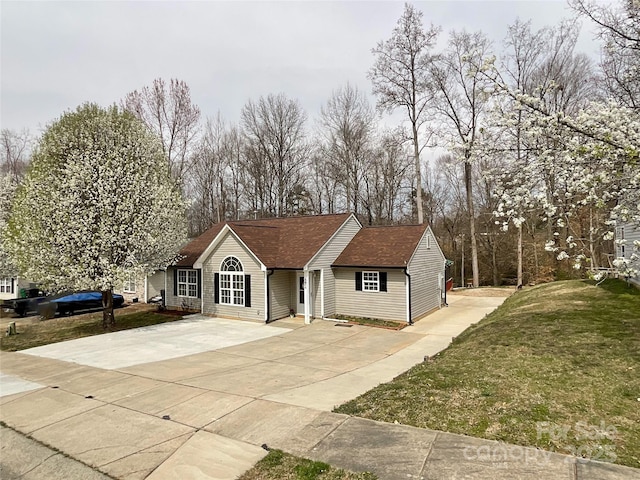 single story home with driveway and a front yard