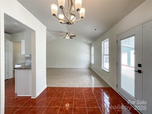 tiled empty room with visible vents, ceiling fan with notable chandelier, baseboards, and vaulted ceiling