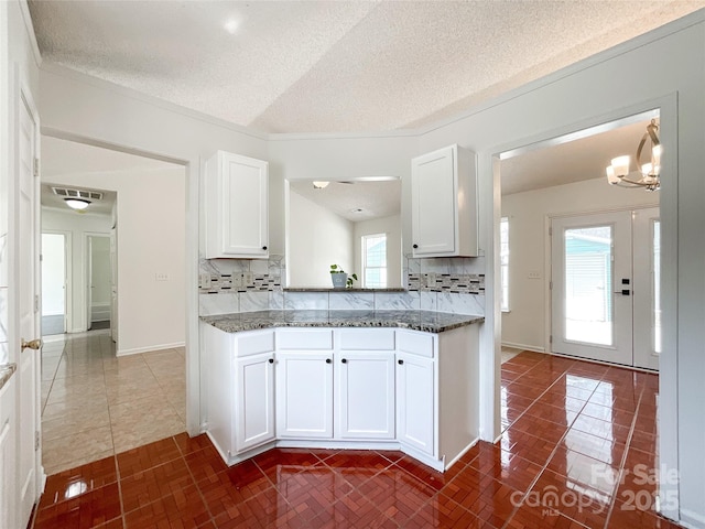 kitchen featuring dark stone countertops, tasteful backsplash, and white cabinetry