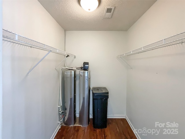 laundry room with visible vents, a textured ceiling, wood finished floors, baseboards, and laundry area