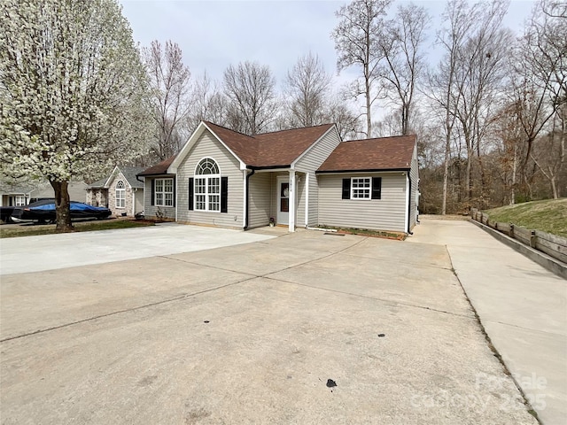 single story home with driveway and roof with shingles