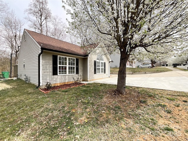 view of front facade with concrete driveway and a front yard